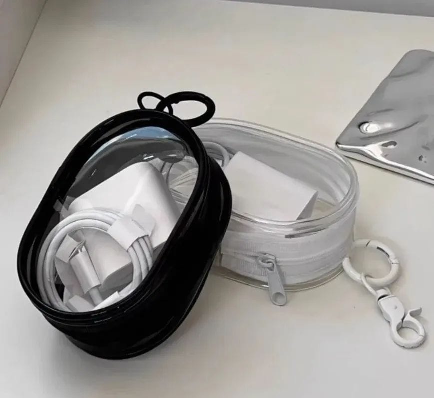 Portable mini transparent zipper pouch with a keychain, designed in an oval shape to neatly organize a phone charger and coiled cable
