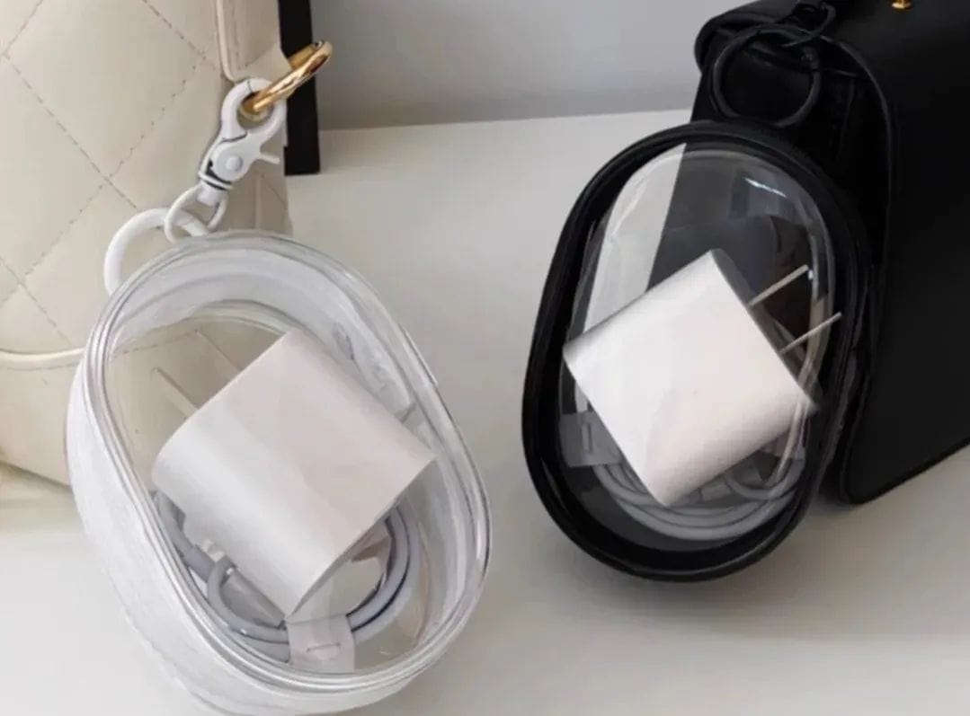 Portable mini transparent zipper pouch with a keychain, designed in an oval shape to neatly organize a phone charger and coiled cable